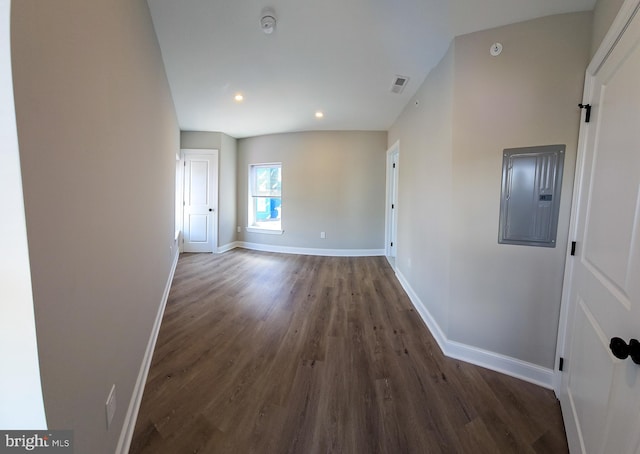 spare room featuring dark wood-type flooring and electric panel