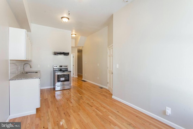 kitchen with white cabinetry, light stone counters, tasteful backsplash, light wood-type flooring, and electric range