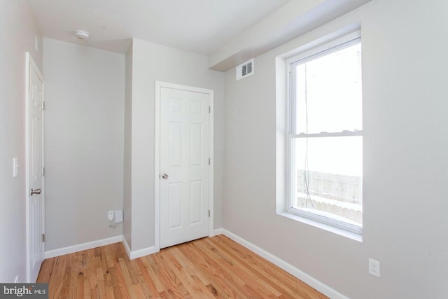 unfurnished bedroom with multiple windows and light hardwood / wood-style floors