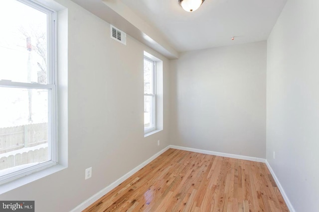 spare room featuring plenty of natural light and light hardwood / wood-style floors