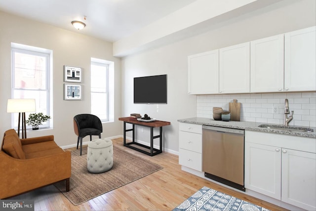 kitchen with white cabinets, a healthy amount of sunlight, sink, and dishwasher