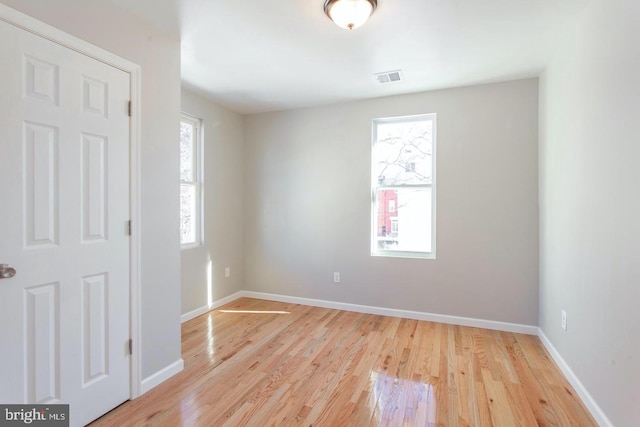 unfurnished room featuring light hardwood / wood-style floors and plenty of natural light