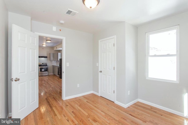 empty room featuring a wealth of natural light and light hardwood / wood-style floors