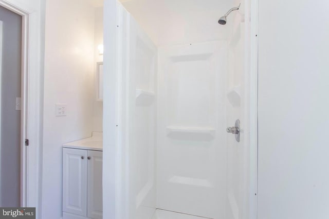 bathroom with walk in shower and vanity