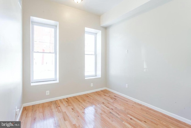 spare room featuring light wood-type flooring and a wealth of natural light