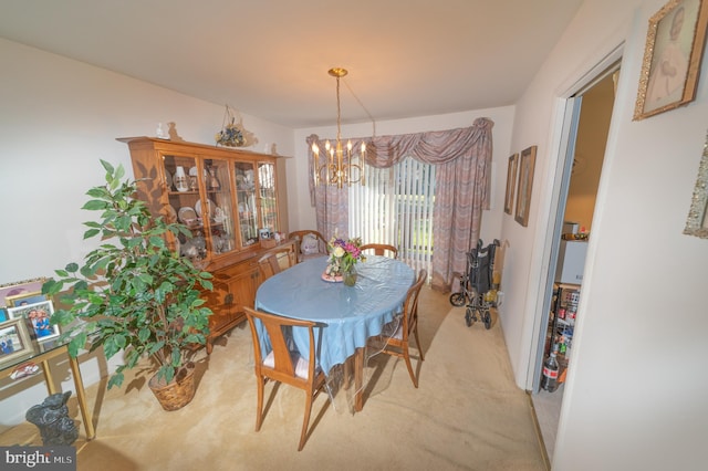 carpeted dining area with a chandelier