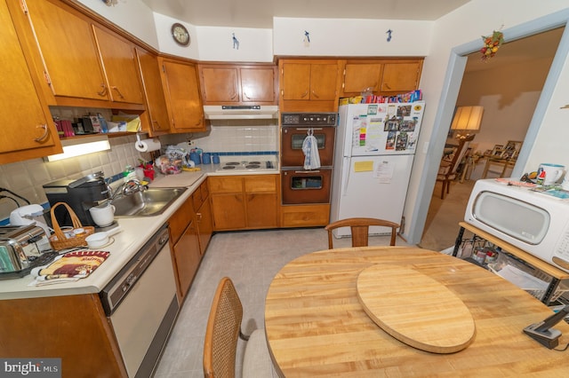 kitchen featuring white appliances, sink, and decorative backsplash