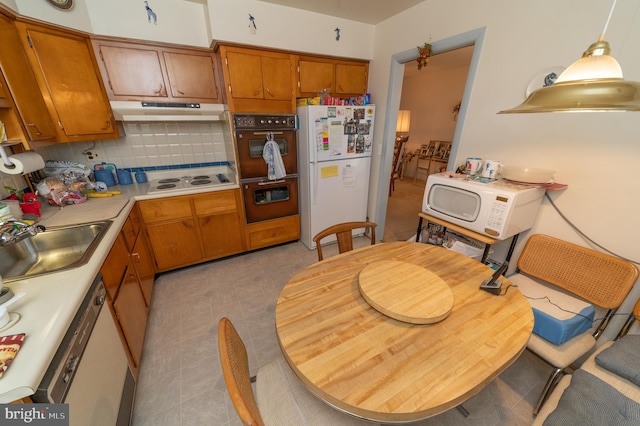 kitchen featuring light tile patterned flooring, sink, hanging light fixtures, white appliances, and decorative backsplash