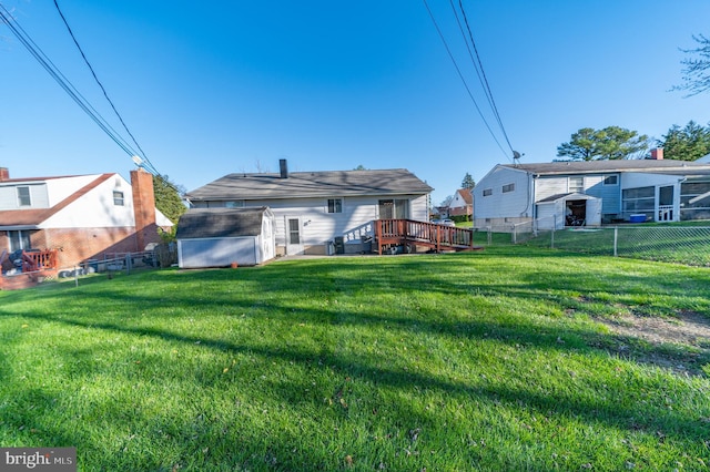 rear view of house with a yard and a wooden deck