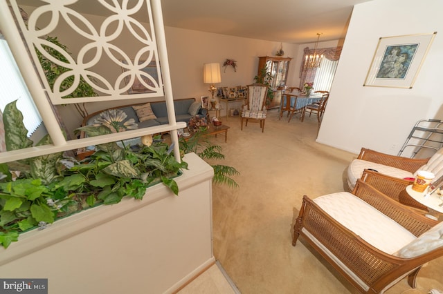 sitting room featuring plenty of natural light, an inviting chandelier, and carpet