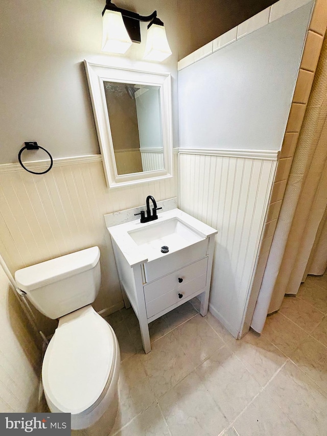 bathroom with tile patterned flooring, vanity, and toilet