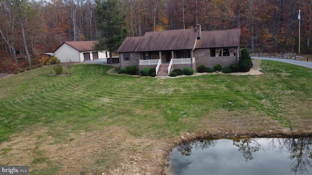 ranch-style home with a porch, a water view, and a front lawn