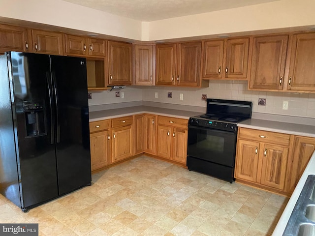 kitchen featuring black appliances and tasteful backsplash