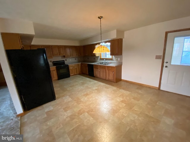 kitchen featuring black appliances, sink, and decorative light fixtures