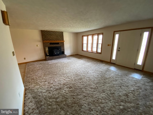 unfurnished living room featuring a brick fireplace and a textured ceiling