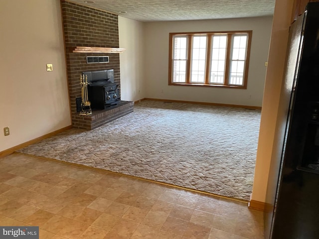 unfurnished living room featuring a textured ceiling, light carpet, and a wood stove