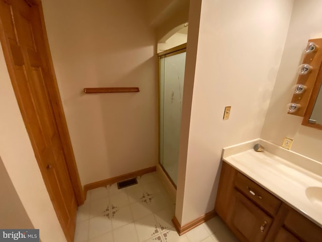 bathroom with vanity, an enclosed shower, and tile patterned floors