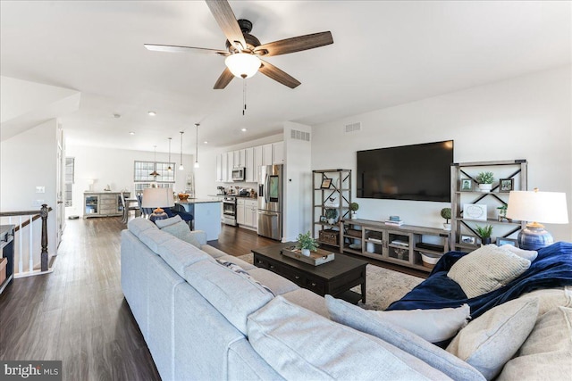 living room with ceiling fan and dark hardwood / wood-style flooring