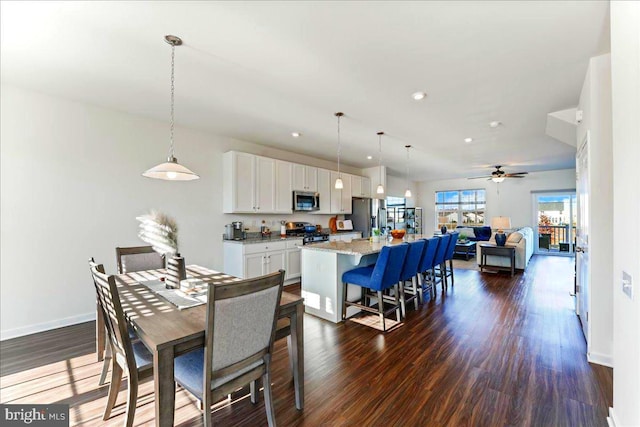 dining area with ceiling fan and dark wood-type flooring