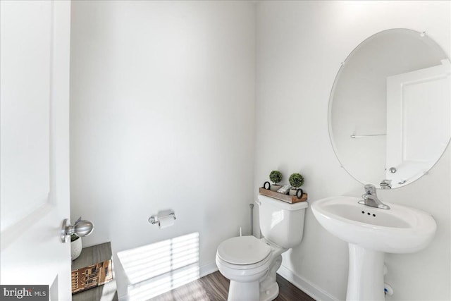 bathroom featuring wood-type flooring and toilet