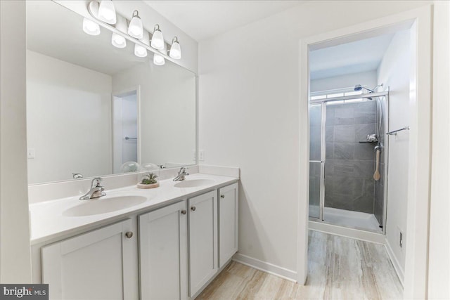 bathroom featuring vanity, a shower with shower door, and wood-type flooring