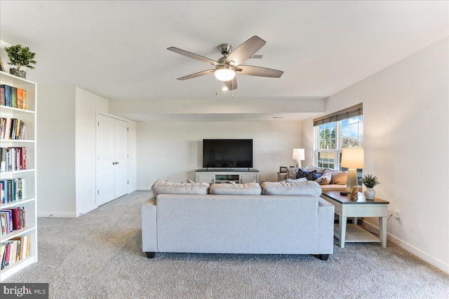 carpeted living room with ceiling fan