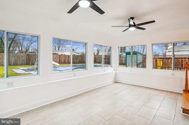 unfurnished sunroom with ceiling fan