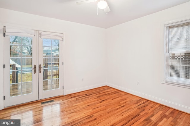 empty room with ceiling fan, french doors, and light wood-type flooring