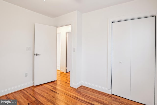 unfurnished bedroom featuring a closet and light wood-type flooring