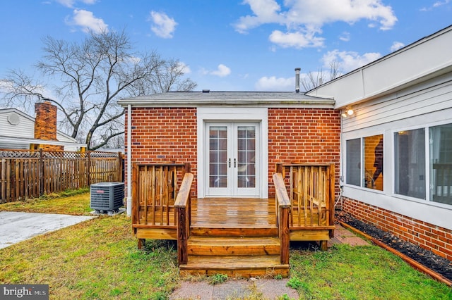 deck with central air condition unit, a yard, and french doors