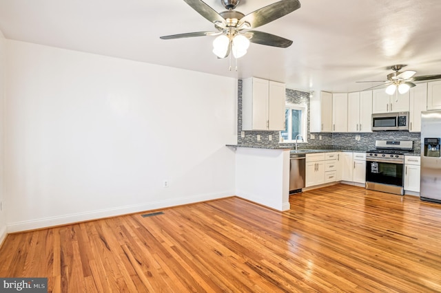 kitchen featuring white cabinets, light hardwood / wood-style floors, and stainless steel appliances