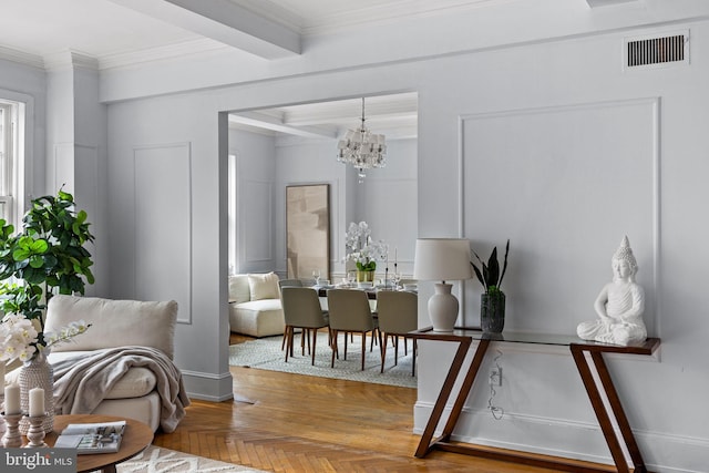 interior space featuring a chandelier, ornamental molding, parquet floors, and beamed ceiling