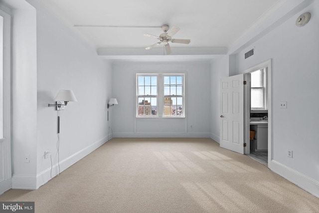 unfurnished bedroom featuring light carpet, ceiling fan, and connected bathroom