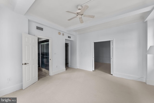 unfurnished bedroom featuring a spacious closet, ceiling fan, a closet, and light carpet