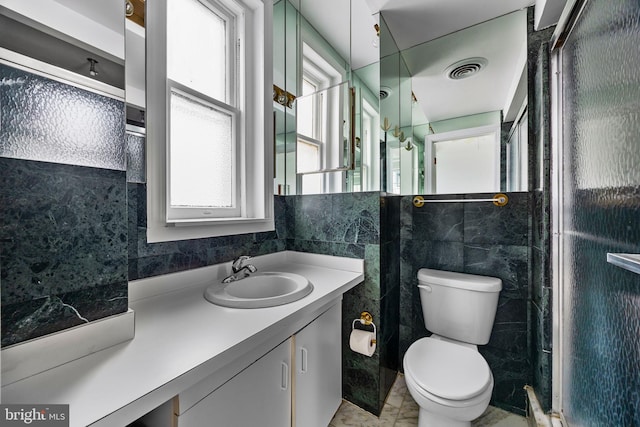 bathroom with tile walls, toilet, walk in shower, and vanity