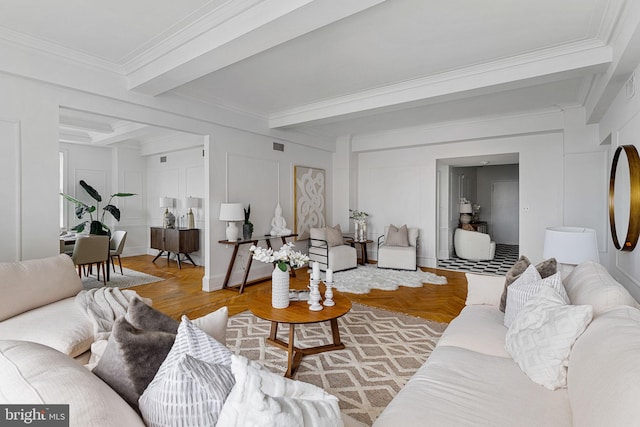 living room featuring light parquet floors, ornamental molding, and beam ceiling