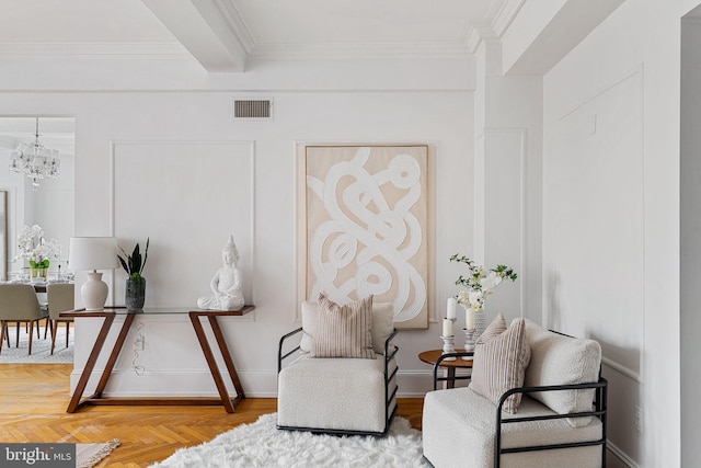 living area with an inviting chandelier, parquet floors, and ornamental molding