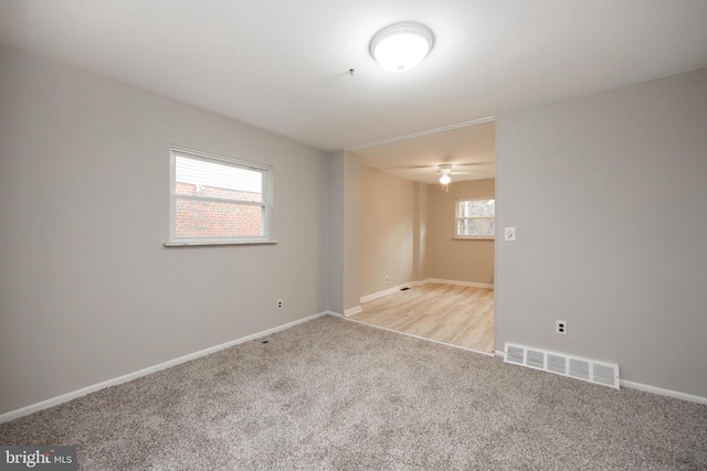 carpeted spare room with ceiling fan and a healthy amount of sunlight