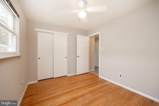 unfurnished bedroom with light hardwood / wood-style floors, ceiling fan, and a closet