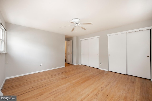 unfurnished bedroom featuring ceiling fan, multiple closets, and light hardwood / wood-style flooring