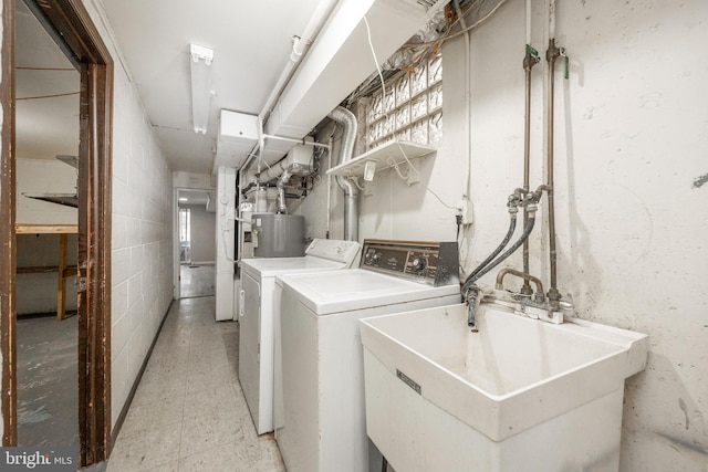 laundry room featuring washer and clothes dryer, sink, and gas water heater