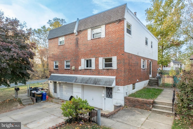 rear view of house featuring a garage