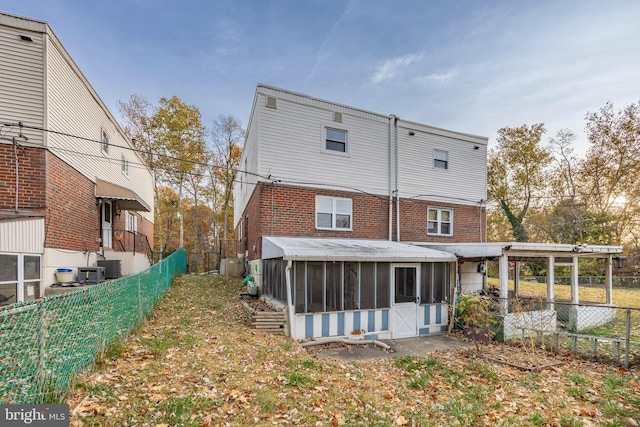 rear view of property featuring a sunroom