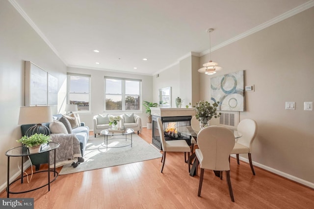 interior space featuring a multi sided fireplace, light hardwood / wood-style floors, and crown molding