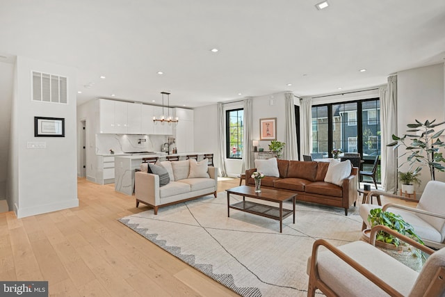 living room featuring an inviting chandelier and light hardwood / wood-style floors