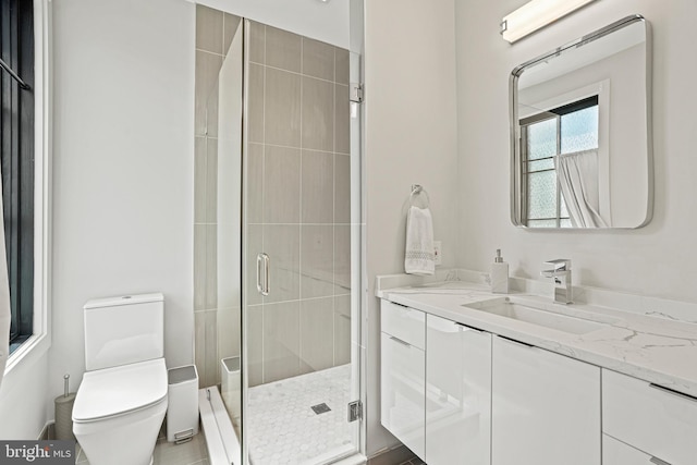 bathroom with a shower with shower door, vanity, and toilet