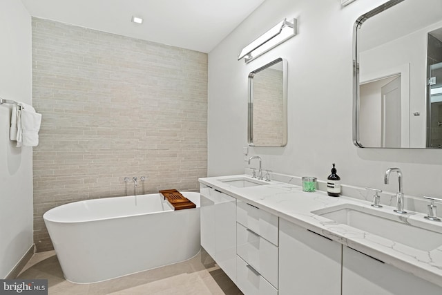 bathroom featuring vanity, a tub to relax in, tile walls, and tile patterned floors