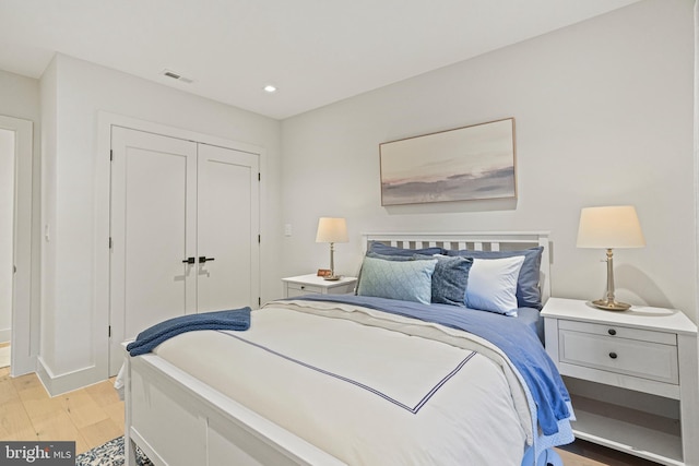 bedroom with light hardwood / wood-style flooring and a closet