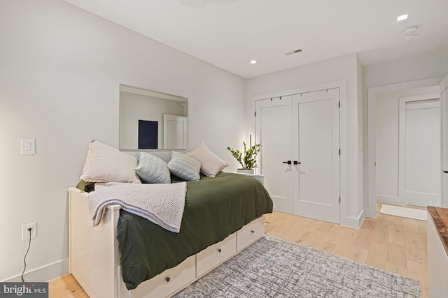 bedroom with light hardwood / wood-style flooring and a closet