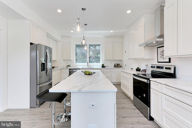 kitchen featuring white cabinetry, a center island, wall chimney exhaust hood, and appliances with stainless steel finishes